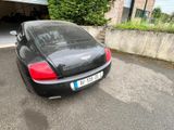 a black car parked in front of a garage