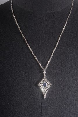 a woman wearing a necklace with a diamond pendant on it