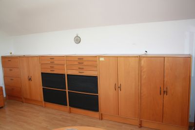 a living room with a couch, cabinets and a coffee table