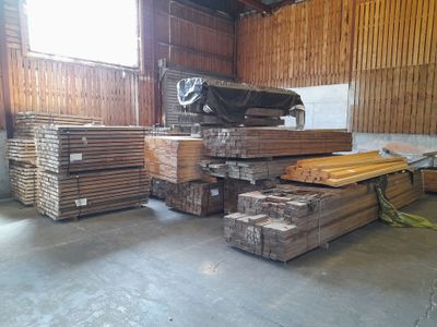 a large pile of wood in a building with a lot of windows