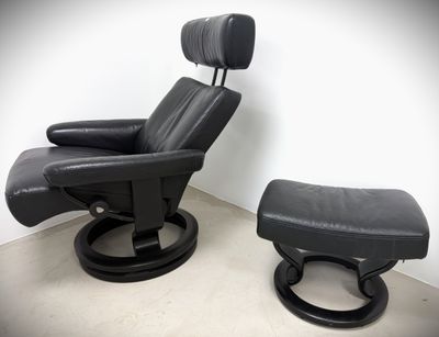 black leather reclining chair and ottoman in a corner of a room
