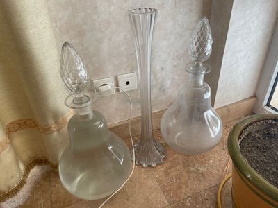 trois vases en verre et un vase en verre posé par terre