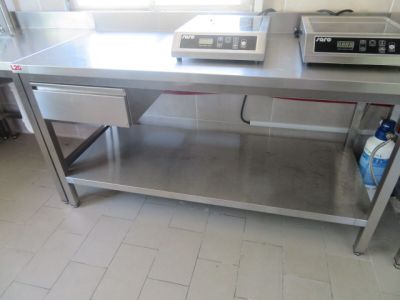 une grande table en acier inoxydable sur laquelle est posé un micro-ondes