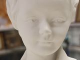 a white statue of a woman with a necklace on her neck