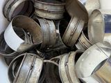 a white bucket filled with old silver cups and spoons