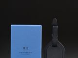 a blue and black luggage tag next to a blue box