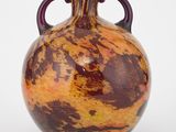 un vase marron et orange muni d'anses, sur un fond blanc