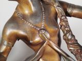 a bronze statue of a woman holding a knife