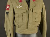 une vieille veste militaire posée sur un mannequin, sur fond noir
