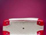 vintage guccissi red and white suitcase on a pink background