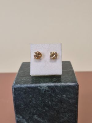 un gros plan sur une paire de boucles d'oreilles posées sur un bloc de marbre