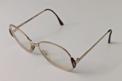 une paire de lunettes posée sur une surface blanche, sur fond blanc
