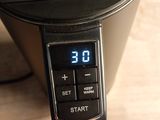 a digital clock on the side of a coffee maker
