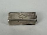 an old silver box with a monogram on it sitting on a white surface