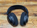 a pair of black headphones sitting on top of a wooden table