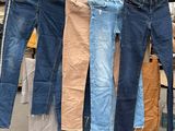 plusieurs paires de jeans suspendues à un portant dans un entrepôt