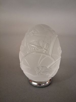 un vase en verre blanc orné d'un motif d'oiseau