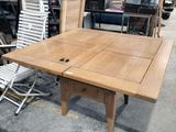 a table and chairs in a warehouse with a lot of furniture