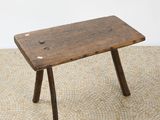 a small wooden bench sitting on top of a tile floor