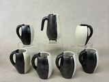 several black and white coffee mugs are arranged in a circle