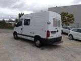 a white van parked in a parking lot next to a white car
