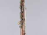 a close up of a wooden clarinet on a clear surface