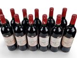 six bottles of red wine lined up in a row on a white surface
