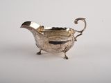 une saucière ancienne en métal argenté, munie d'une poignée et de pieds