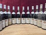 des bouteilles de vin alignées sur une table en bois, sur fond rouge