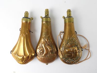three gold colored bottles with designs on them sitting next to each other