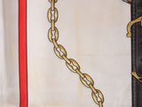 two belts with gold chains on them on a table