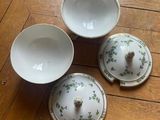 three bowls and a bowl with a lid on a wooden floor