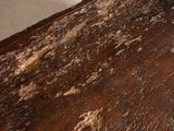 a piece of wood that has been scratched and is sitting on the floor