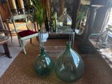 two green glass vases sitting on the floor in the living room