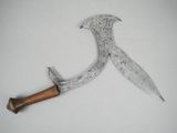 a close up of a knife on a white surface with a wooden handle