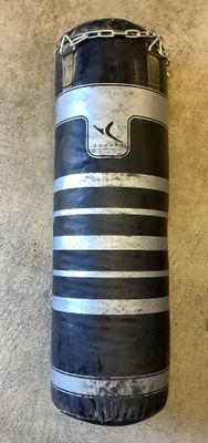 un sac de frappe rayé noir et blanc posé par terre