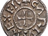 a close up of a silver coin with a cross on it