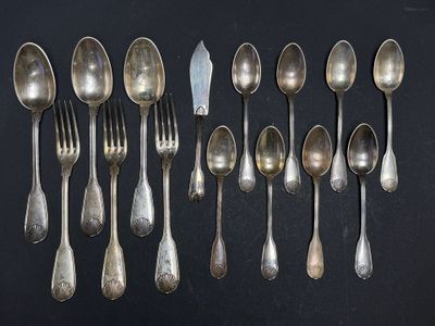 a lot of silver spoons and forks on a black table