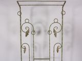 a green metal stand with a mirror on top of it