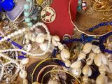 a pile of assorted jewelry on a wooden table