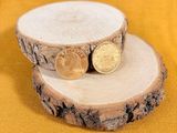 two coins sitting on top of a piece of wood