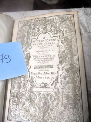 un vieux livre posé sur une table, avec un mot accroché dessus