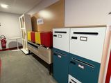 Plusieurs classeurs sont alignés dans une pièce, avec une borne d'incendie en arrière-plan.