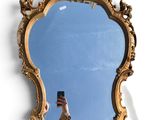 a person taking a picture of a mirror with a cell phone