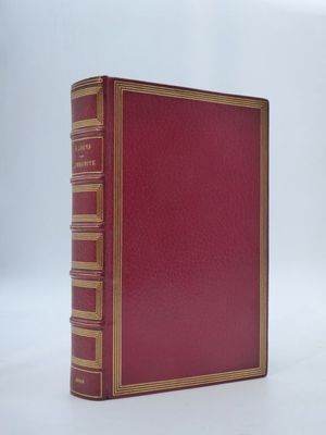 un vieux livre rouge posé sur une table blanche