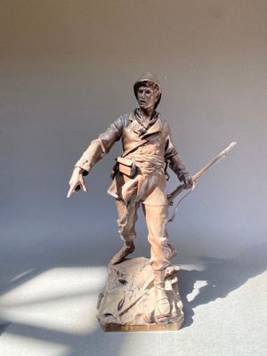 statue d'un homme tenant un fusil, posée sur une surface blanche