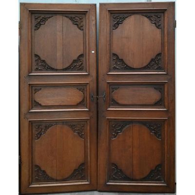 une paire de portes anciennes en bois ornées de sculptures élaborées