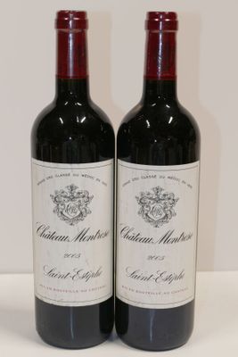 deux bouteilles de vin rouge posées sur une table blanche