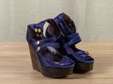 blue wedged sandals with wooden heel and buckles on a wooden surface