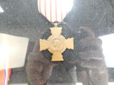 reflet d'une personne tenant une médaille devant un miroir